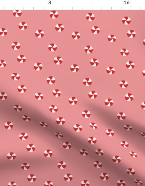 Peppermint Swirls in Red and White Scattered Randomly on Pink Fabric